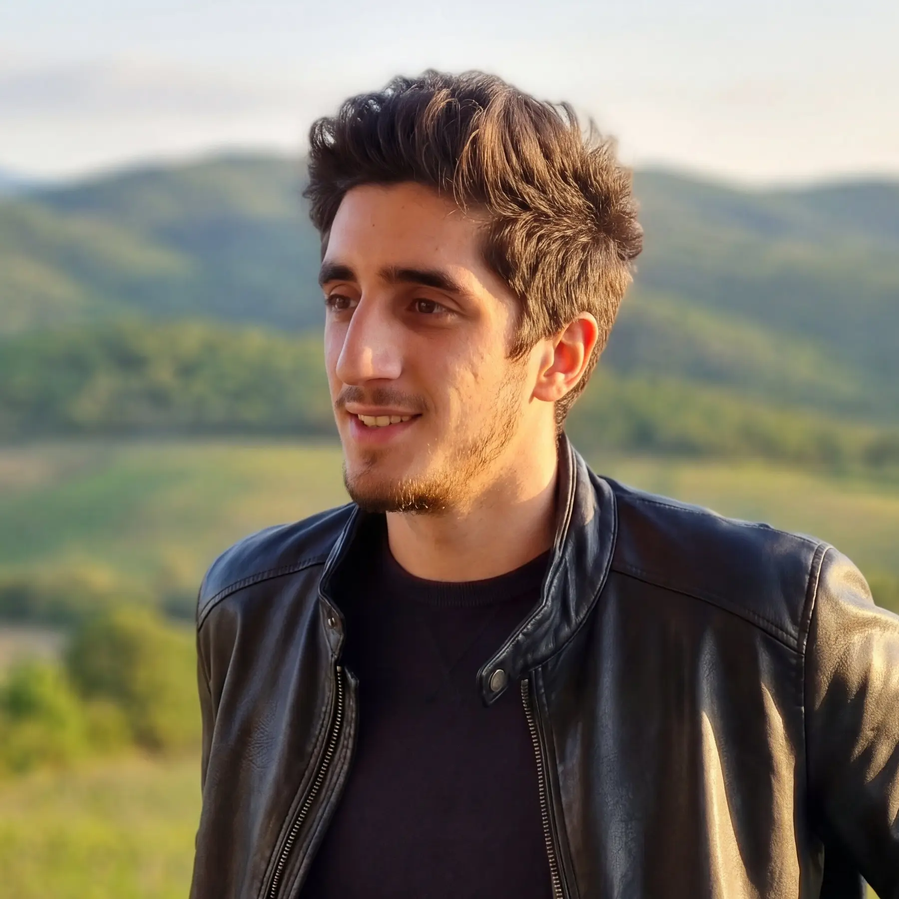 Gigi Gigiloshvili outdoors in a black leather jacket